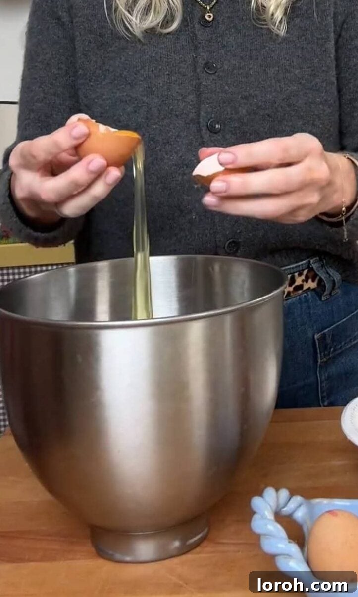 Separating egg whites and yolks carefully into two bowls.