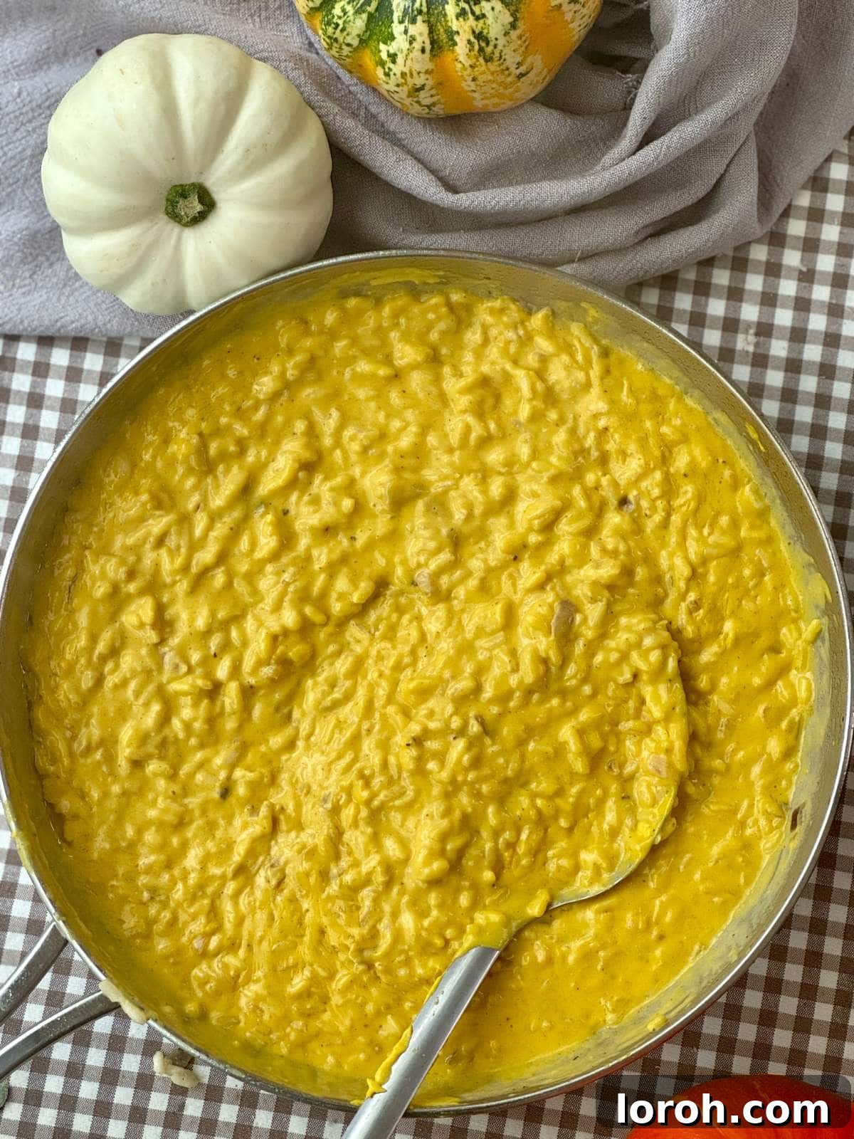 A large pan filled with golden, creamy pumpkin risotto, ready to be served.