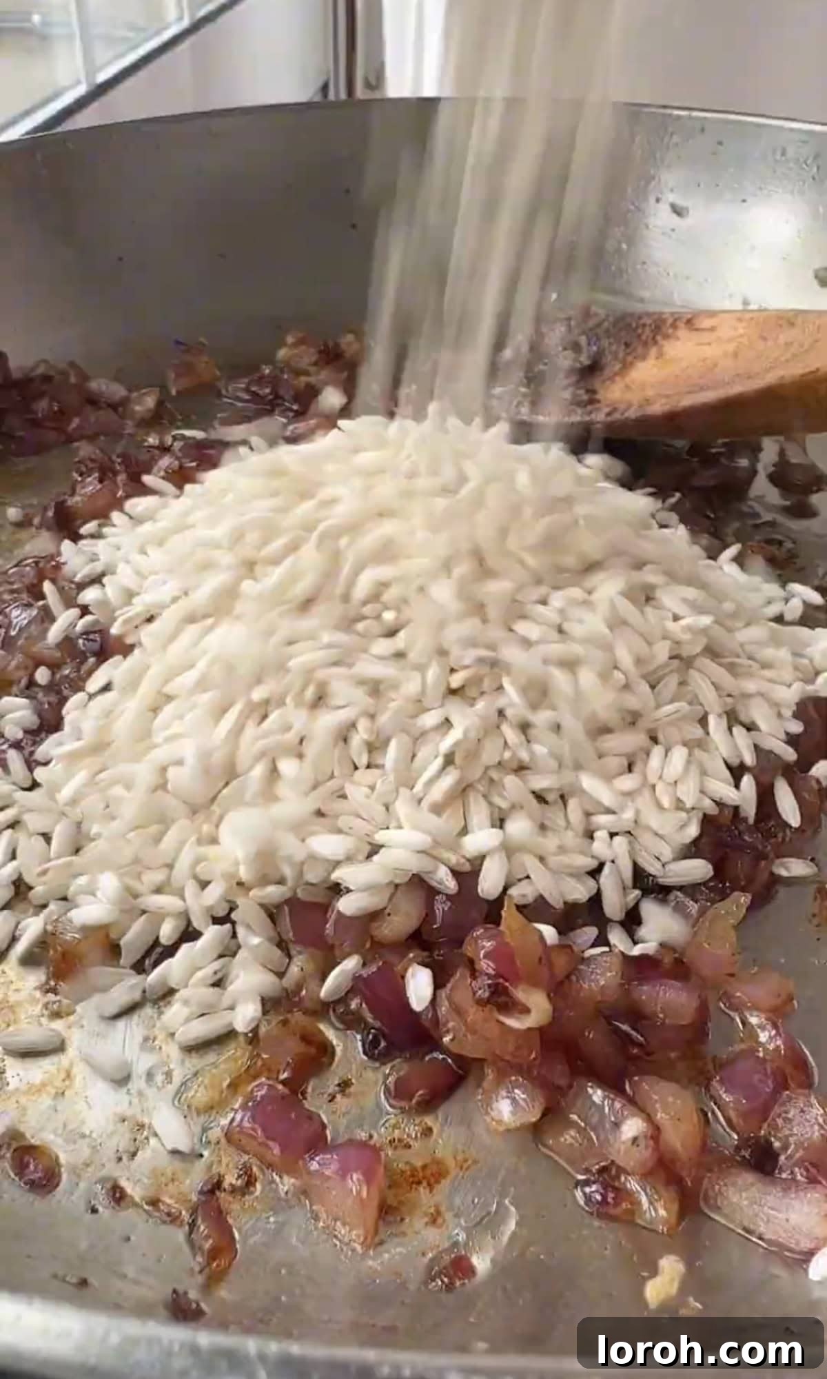 Golden Harvest Pumpkin Risotto 8 Arborio rice grains being stirred into the sautéed onions and garlic in a pan.