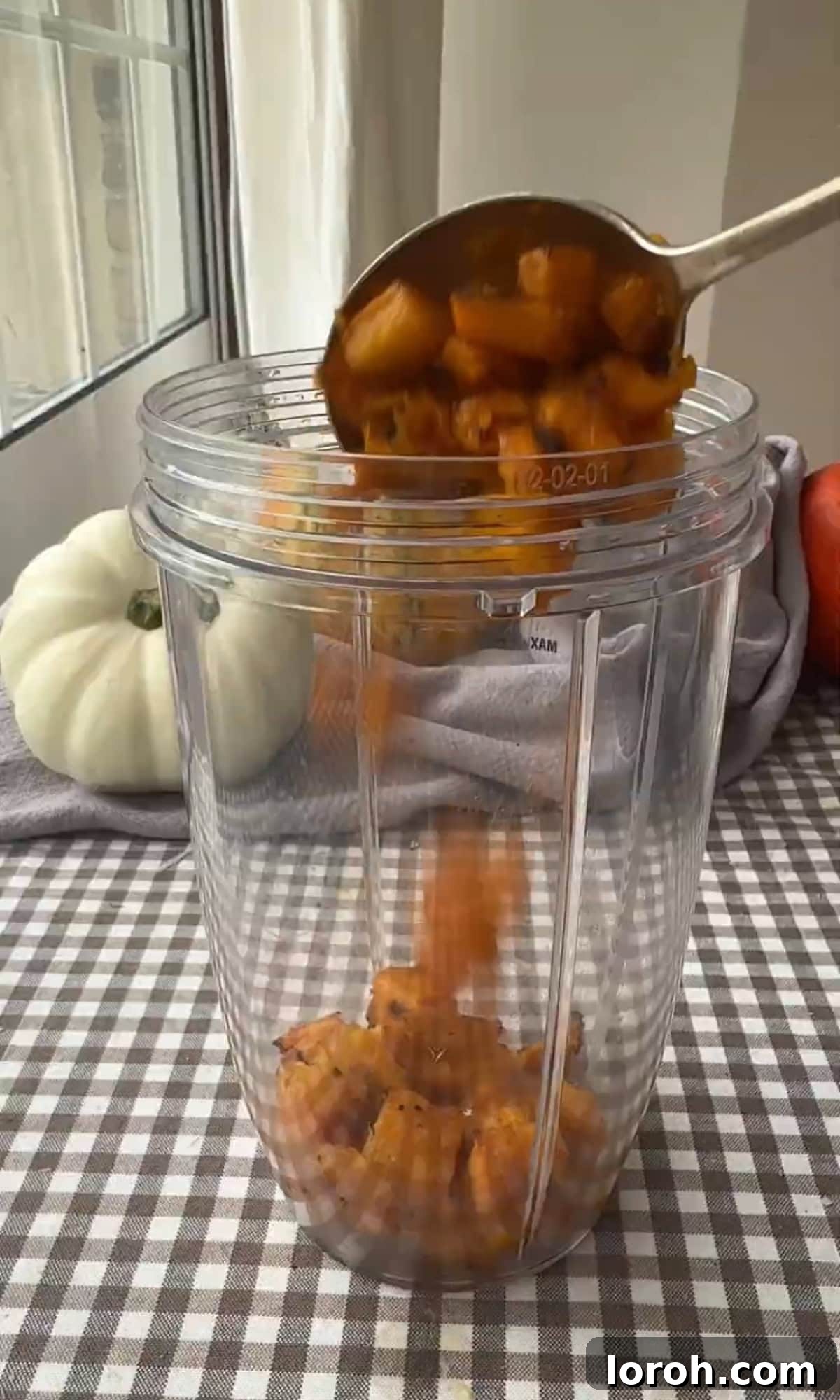 A blender transforming roasted pumpkin cubes with cream into a smooth purée.