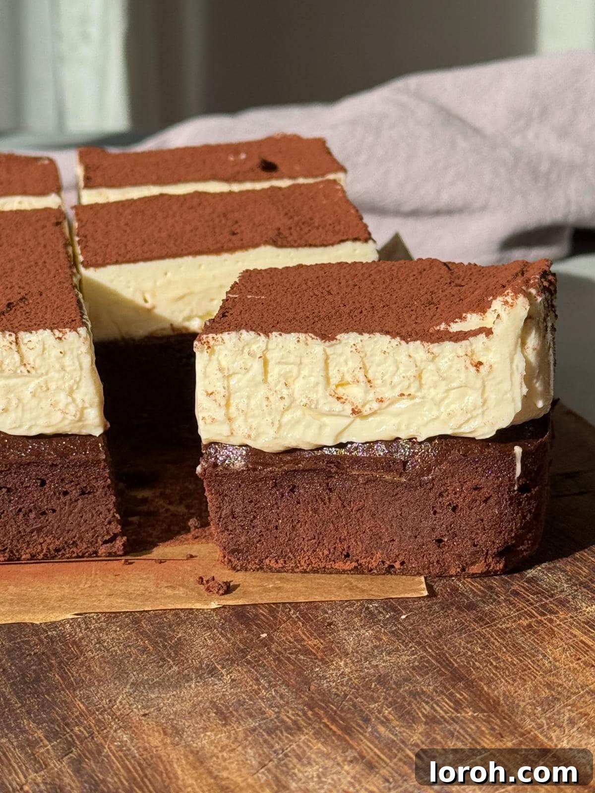 Decadent Cheesecake Brownies 2 One cheesecake brownie sliced, showcasing distinct layers.