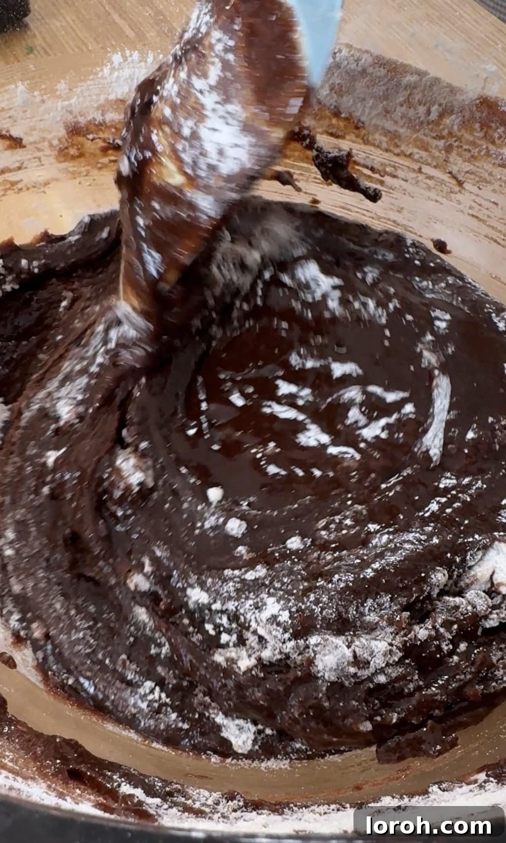 Decadent Cheesecake Brownies 7 Folding brownie batter and pouring into a prepared tin.