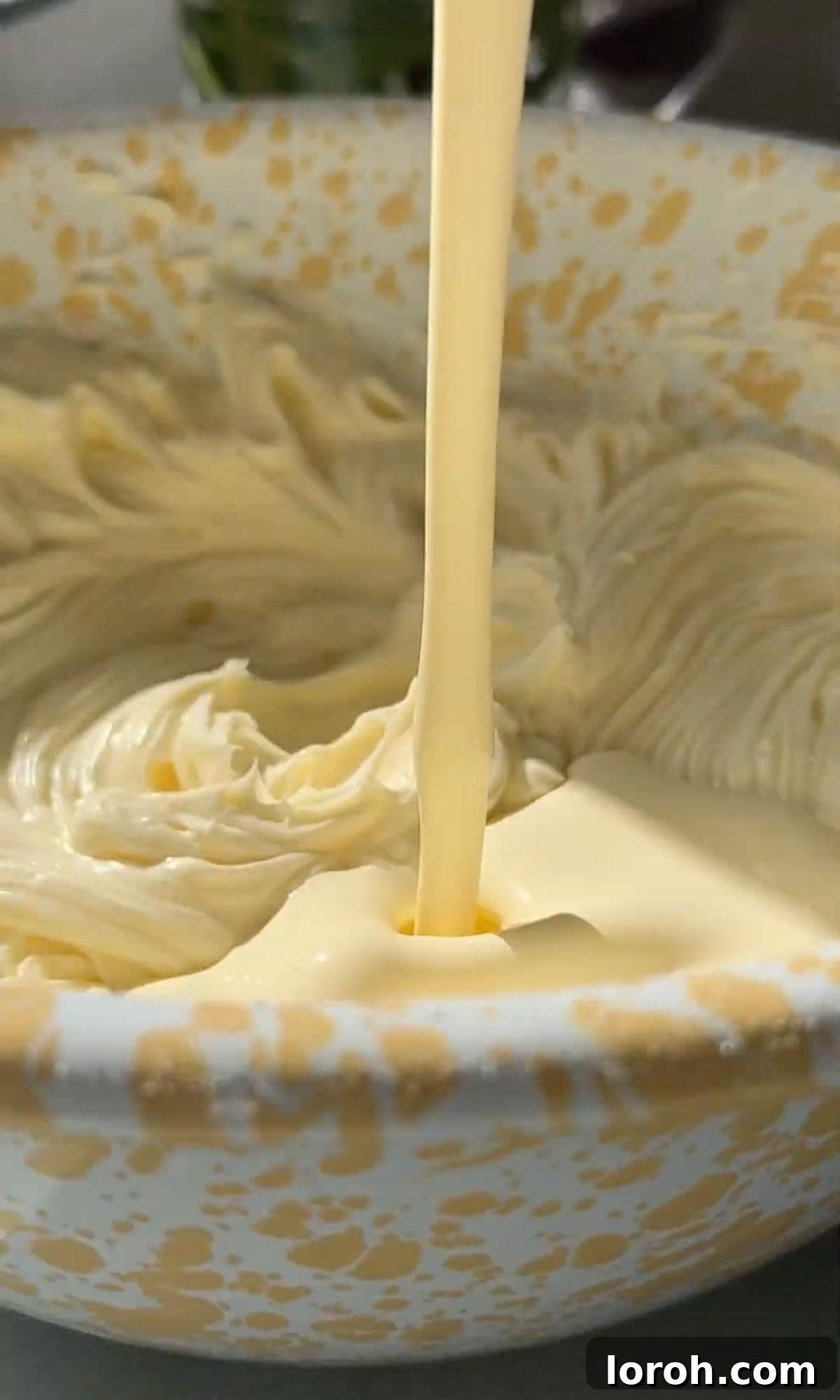 Decadent Cheesecake Brownies 9 Adding cold double cream to the cheesecake mixture.