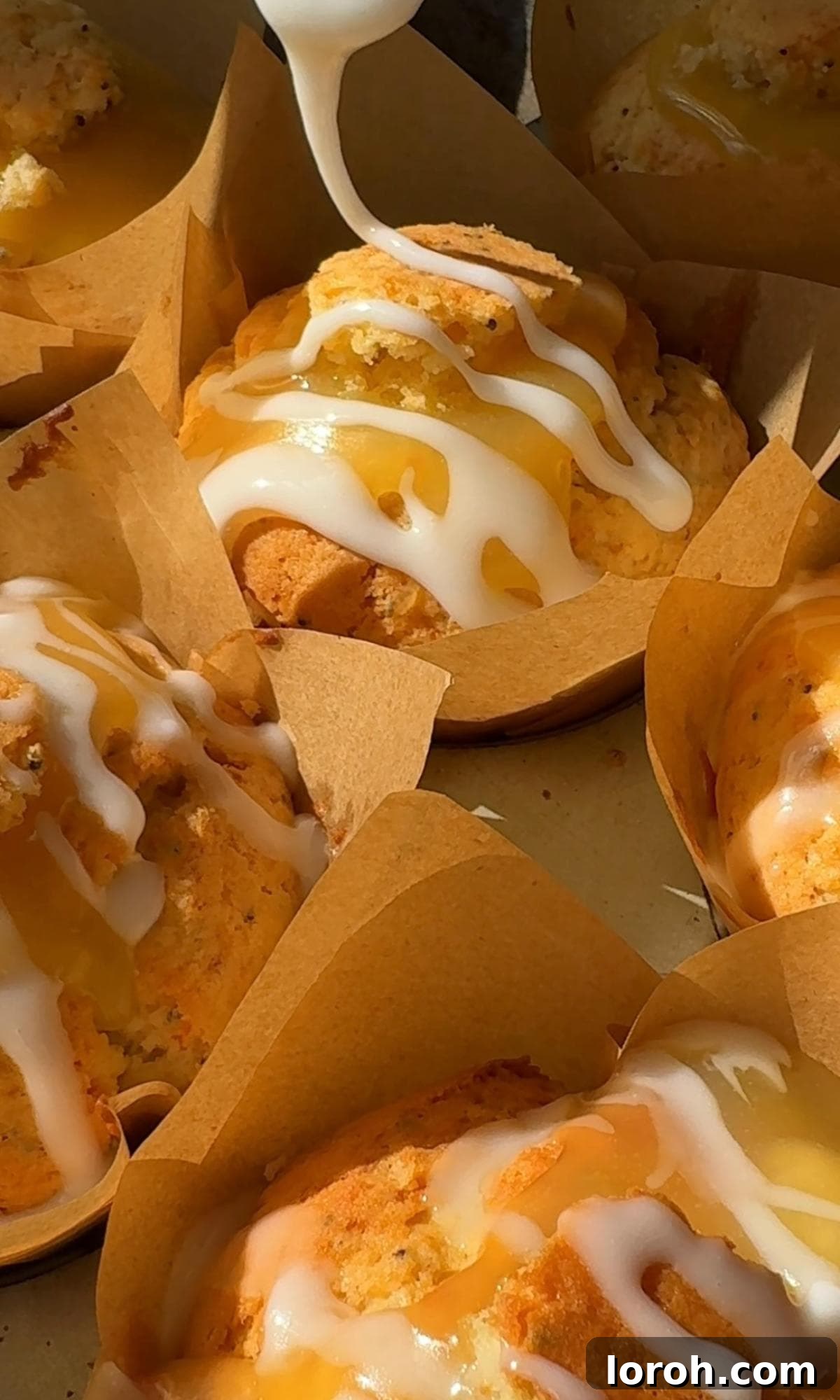 Zesty Lemon Poppy Seed Delights 11 Drizzling a vibrant lemon glaze over a batch of cooled lemon and poppy seed muffins.