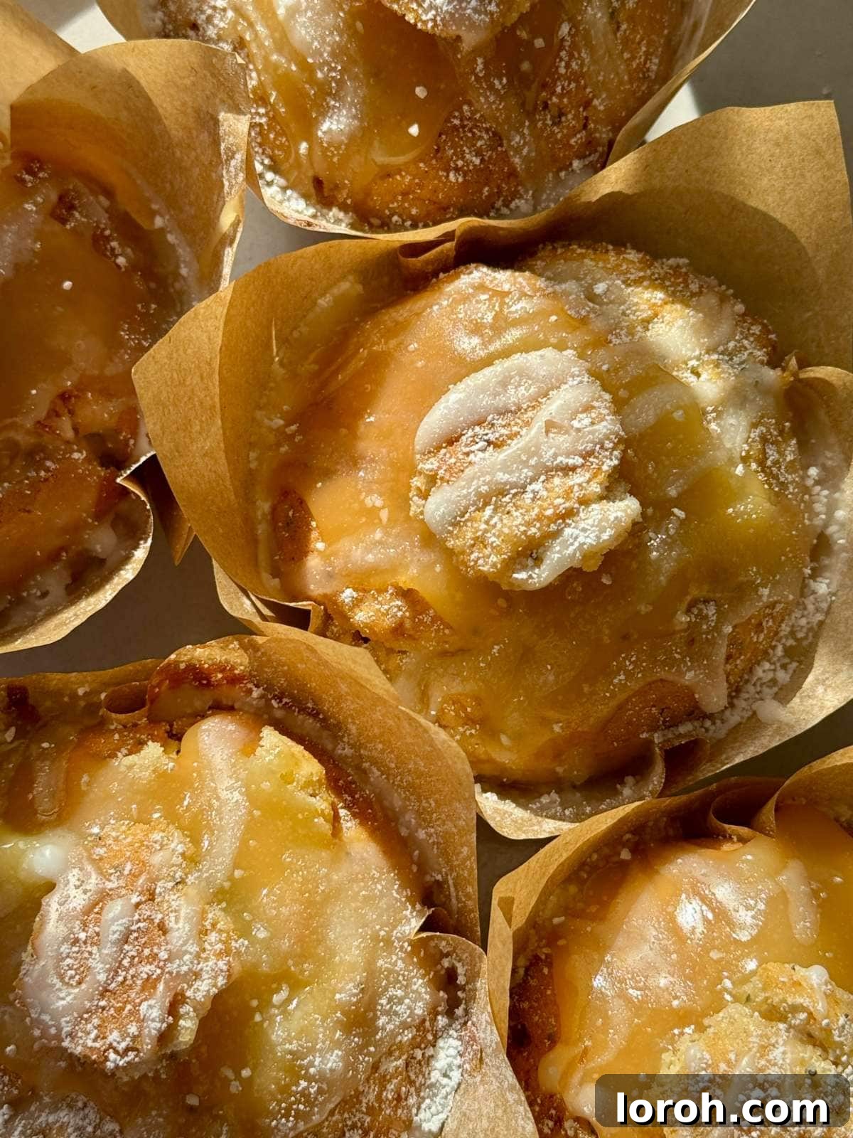 Zesty Lemon Poppy Seed Delights 3 A batch of freshly baked lemon and poppy seed muffins, some drizzled with glaze.