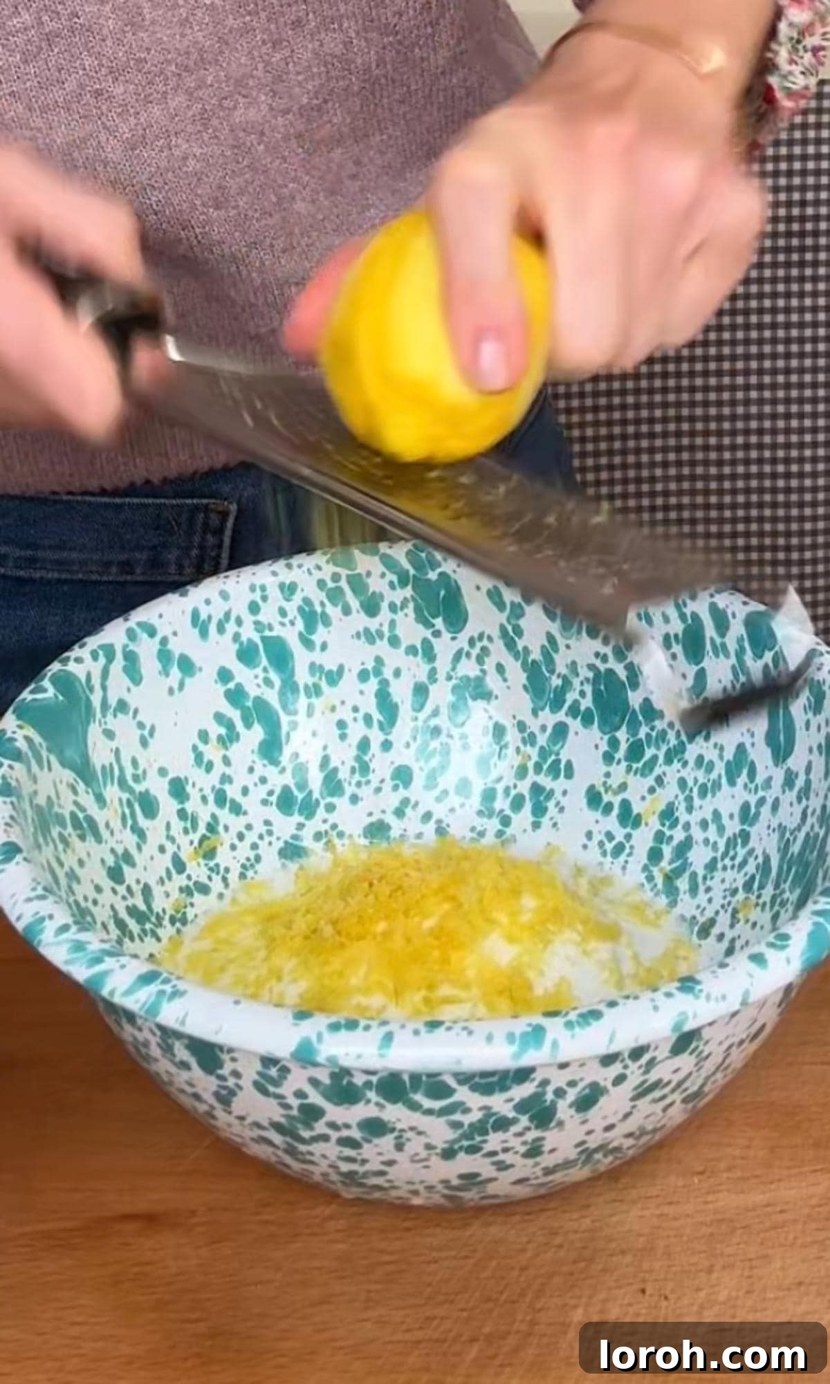 Zesty Lemon Poppy Seed Delights 4 Zesting a fresh lemon directly into a bowl of sugar, illustrating the first step of the muffin recipe.