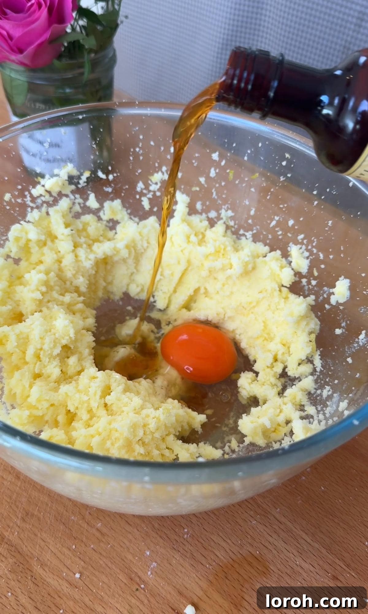 Zesty Lemon Poppy Seed Delights 6 Adding a large egg and vanilla extract to the creamed butter and sugar mixture, ready for mixing.