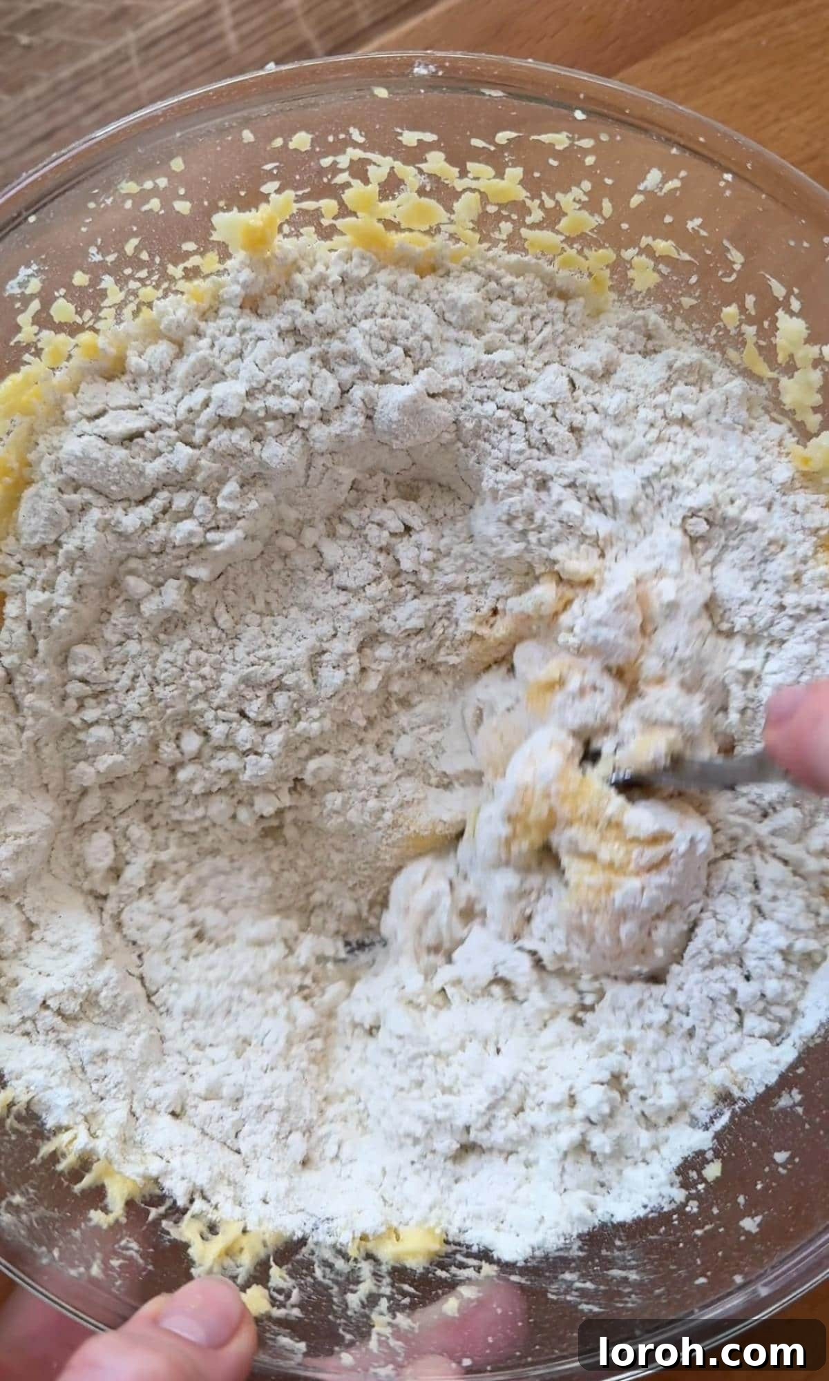 Zesty Lemon Poppy Seed Delights 7 Carefully adding the dry flour mixture into the wet muffin batter.