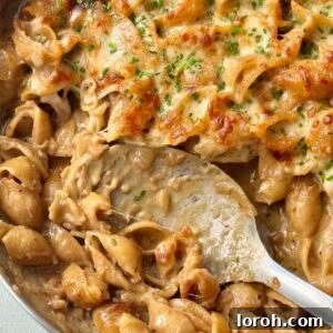 spooning french onion soup pasta. A delicious one-pot meal with a cheesy crust.