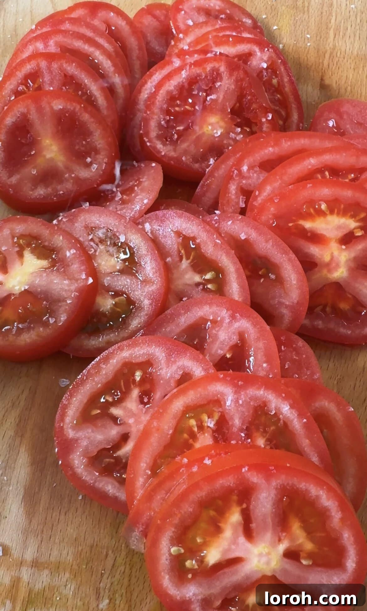 Thinly slicing large ripe tomatoes and seasoning them lightly with salt and pepper.