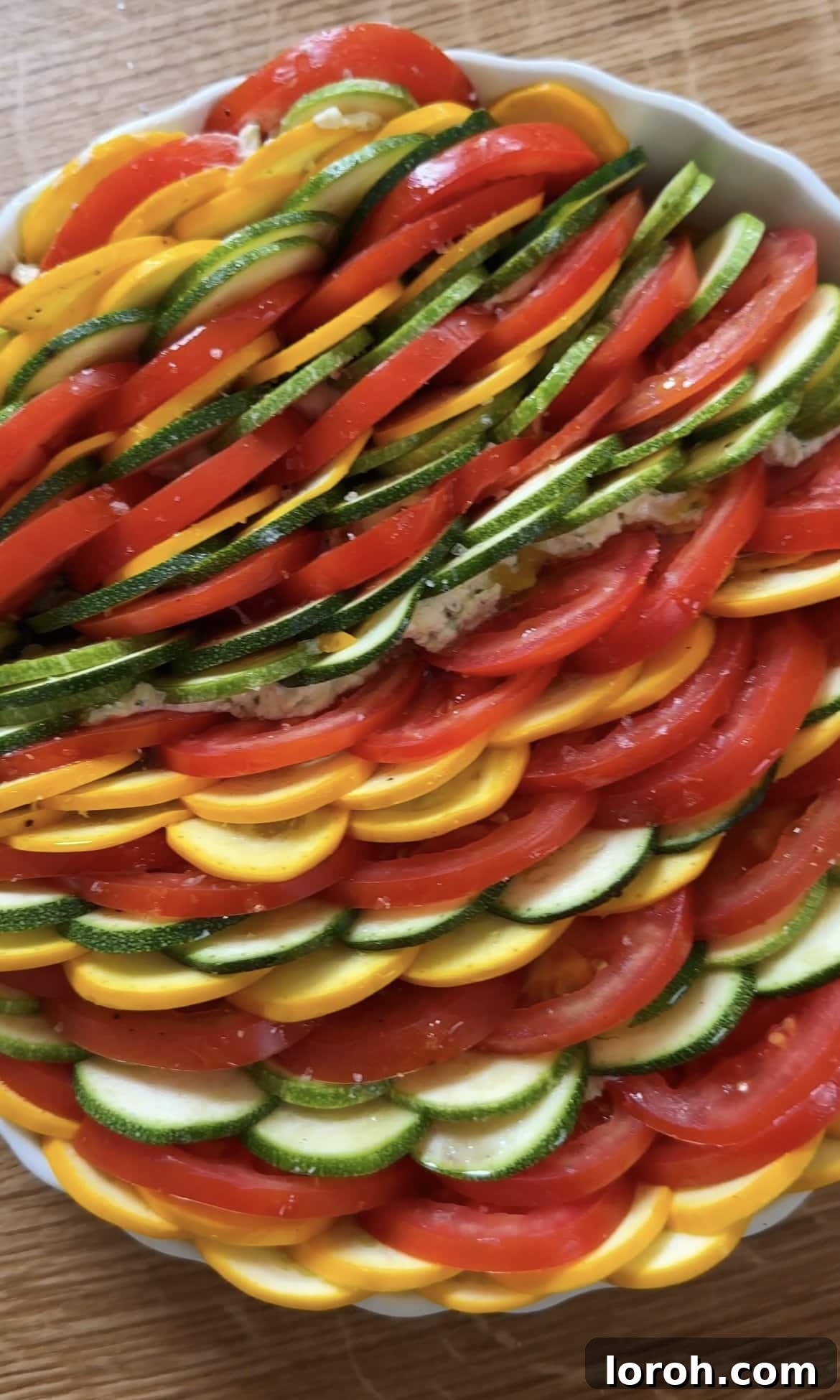 The fully layered zucchini al forno gratin, drizzled with olive oil and seasoned, ready to be baked to golden perfection.