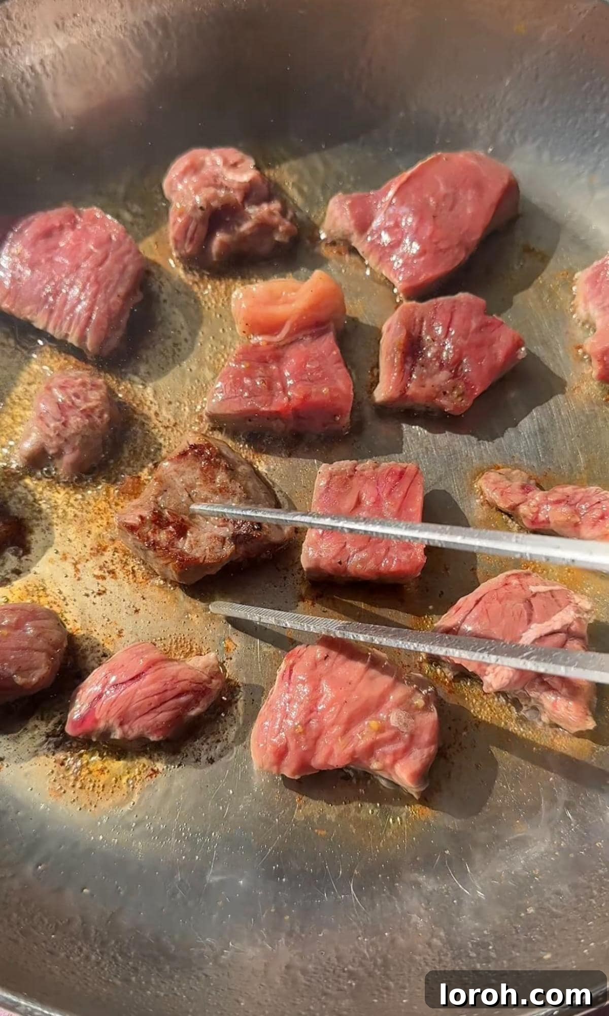 Melt-in-Your-Mouth Garlic Butter Steak Bites 5 Steak bites sizzling in a hot frying pan, forming a beautiful crust.