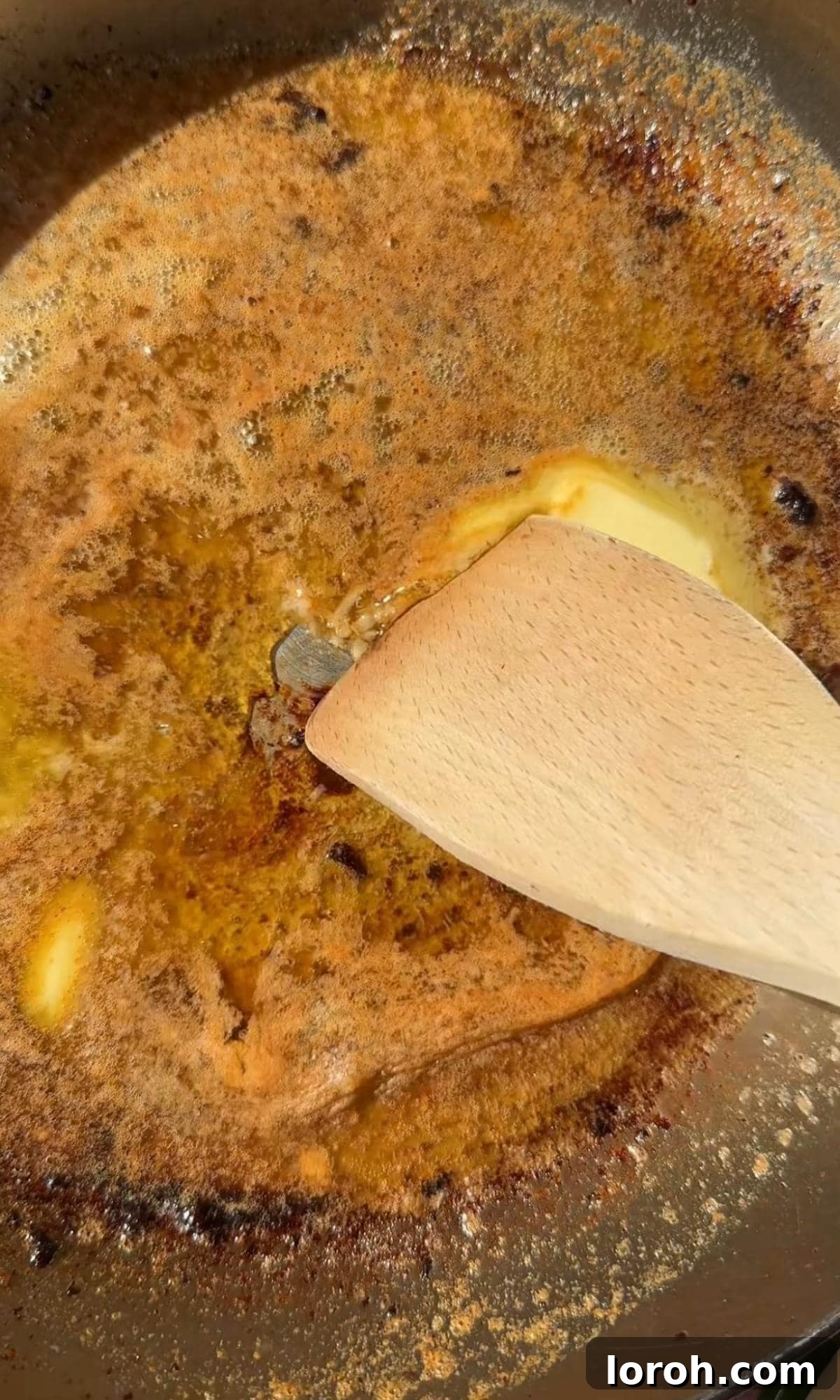 Melt-in-Your-Mouth Garlic Butter Steak Bites 6 Melted butter simmering with grated garlic, Parmesan, and chopped parsley in a pan.