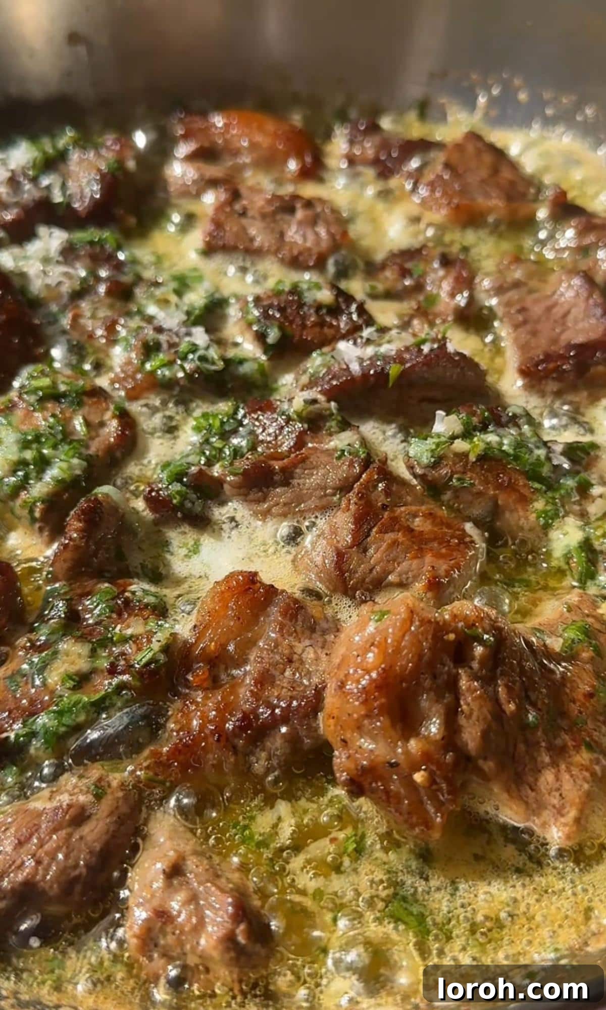 Melt-in-Your-Mouth Garlic Butter Steak Bites 7 Seared steak bites being tossed in the pan with rich garlic butter sauce.