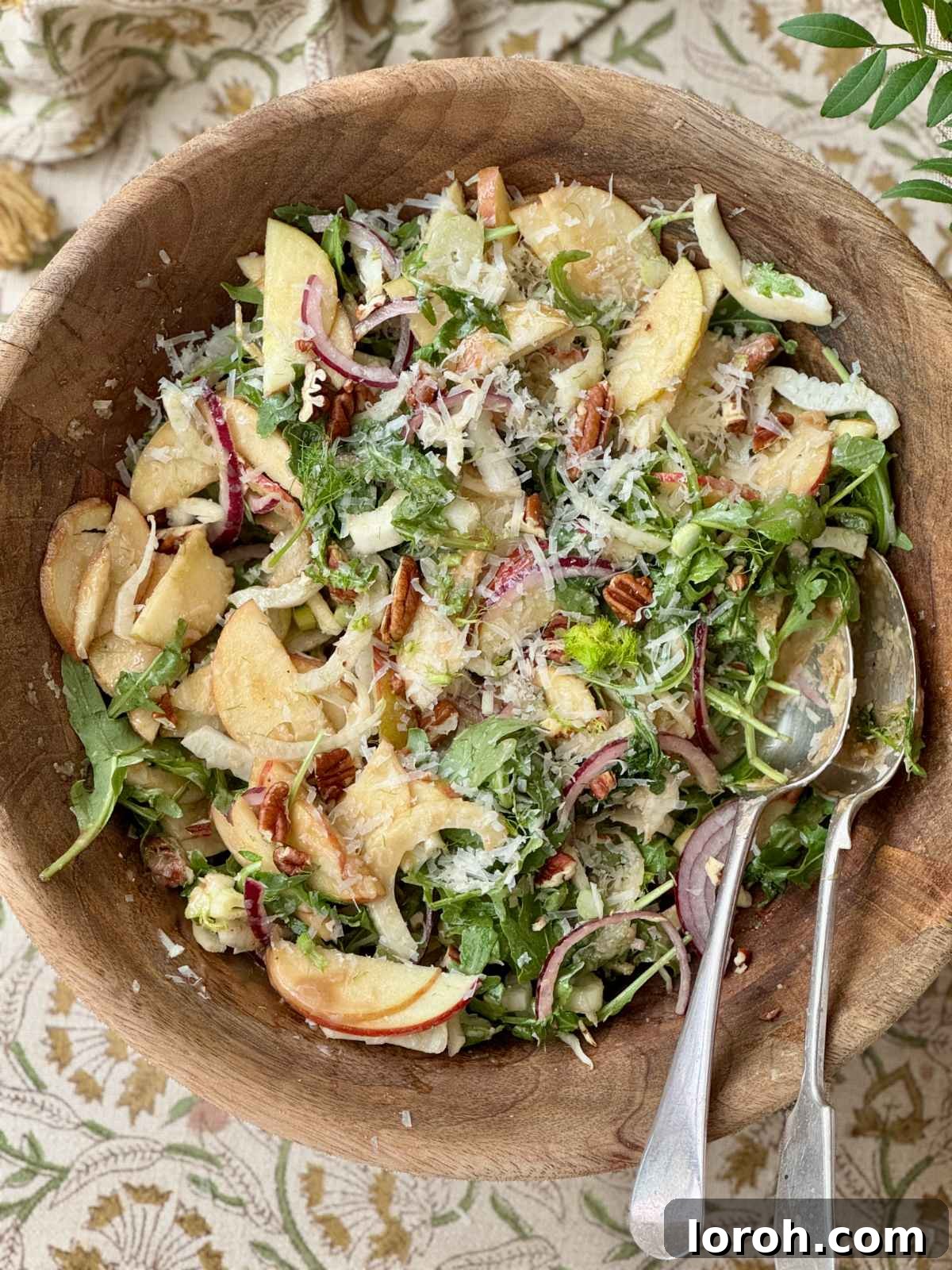 Fennel apple salad in a rustic wooden bowl, showcasing vibrant ingredients.