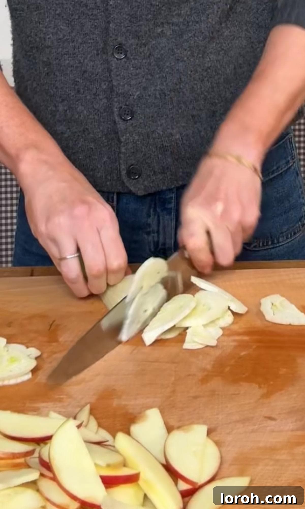 A hand thinly slicing fennel bulb with a mandoline.