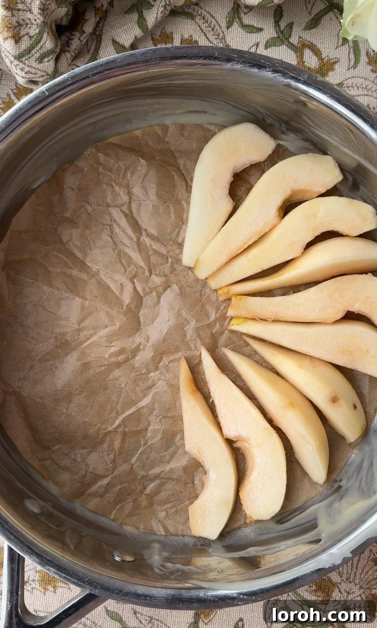 Golden Pear Flip Cake with Decadent Fudge Drizzle 5 Thinly sliced pears meticulously arranged in a beautiful spiral pattern at the bottom of a greased cake tin.