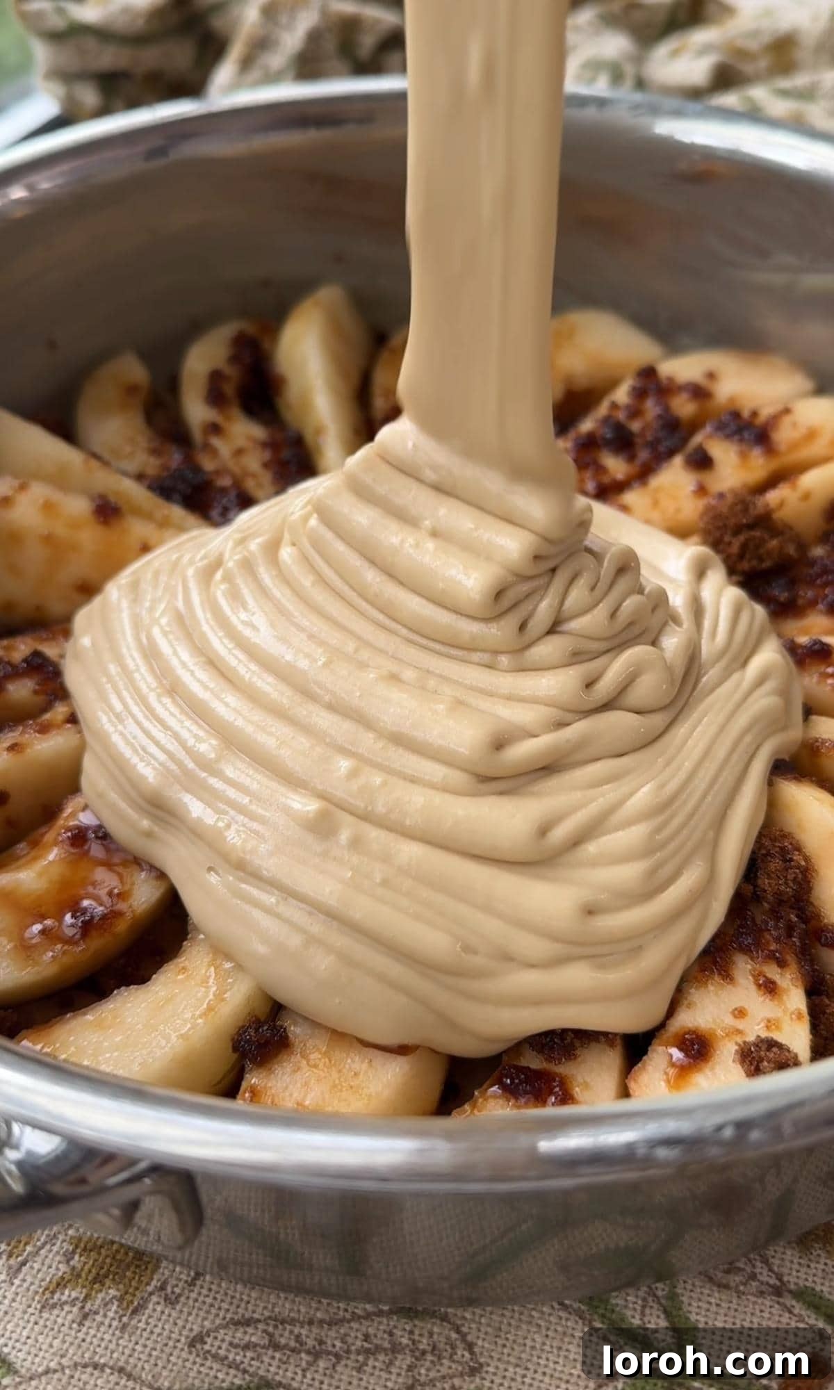 Golden Pear Flip Cake with Decadent Fudge Drizzle 8 Smooth cake batter being carefully poured over the arranged pear slices in the baking tin, ensuring even coverage.