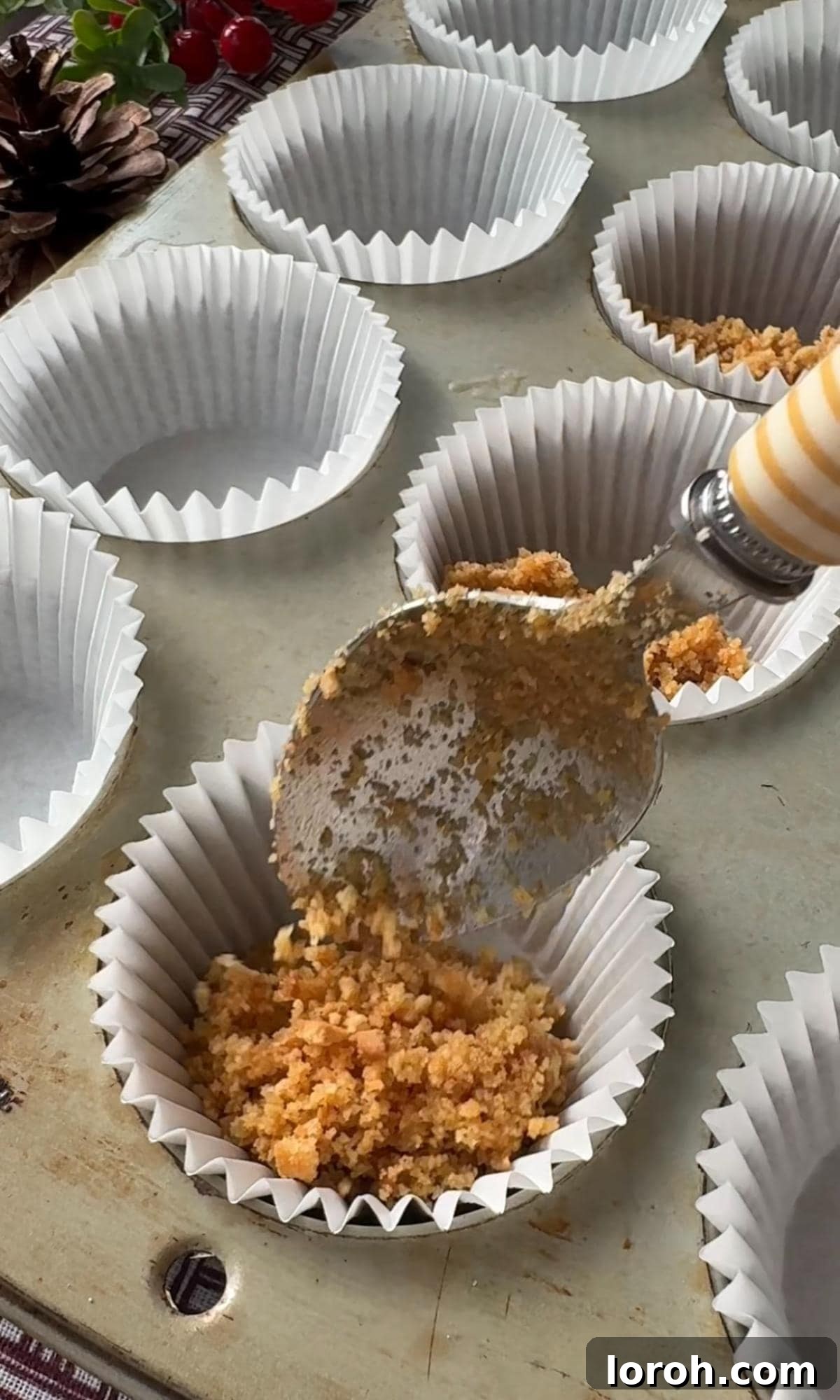 Effortless Christmas Cheesecake Bites 5 adding biscuit base to muffin cases.