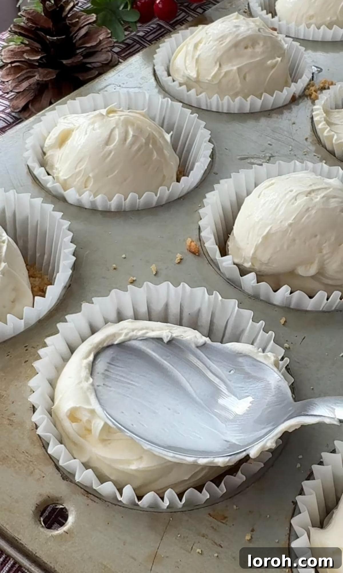 Effortless Christmas Cheesecake Bites 9 smoothing cheesecake into cases.