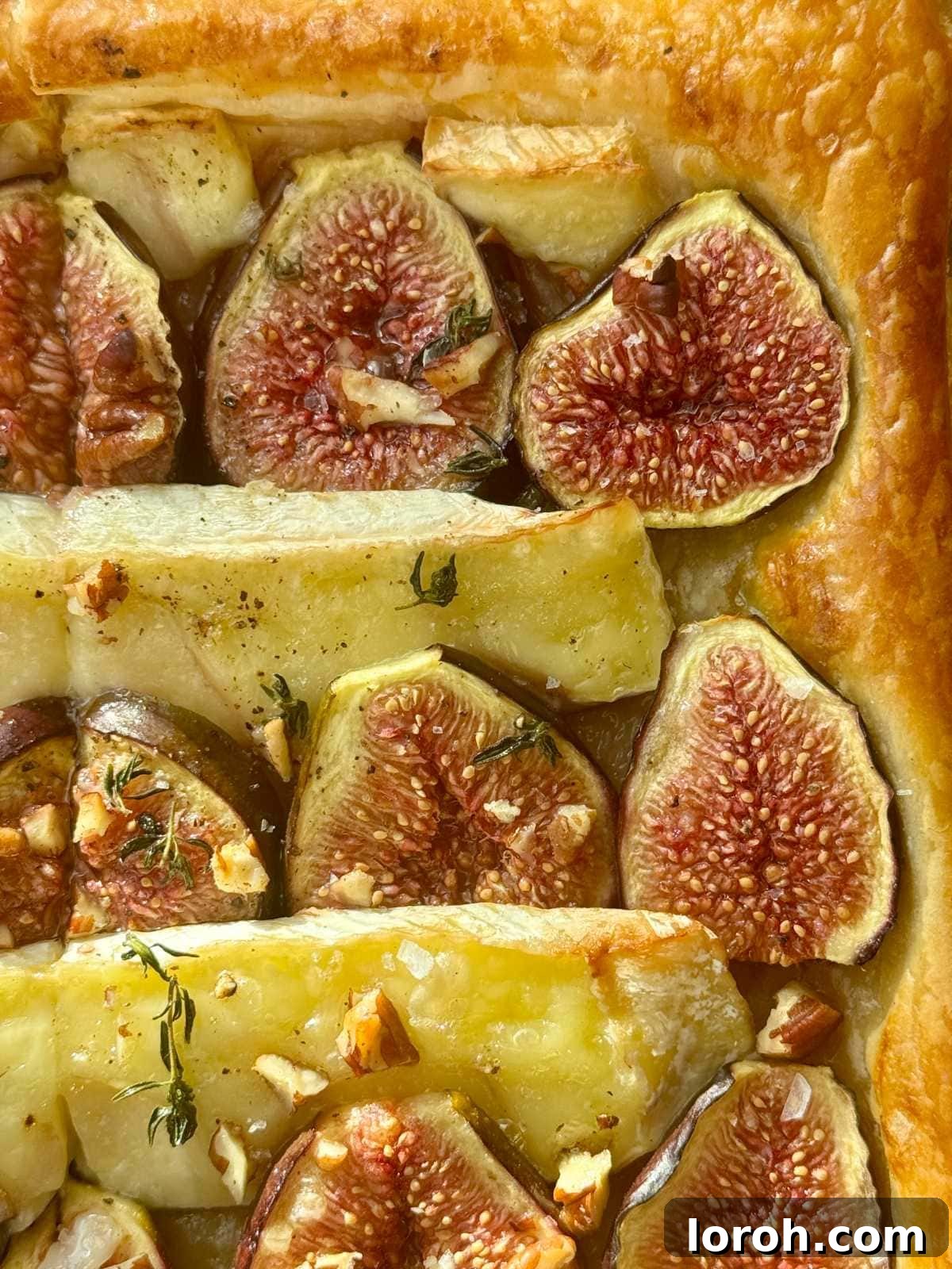 Fig and Brie Bliss Tart 8 A slice of the savoury fig and brie tart being lifted, showcasing its flaky crust and gooey interior.
