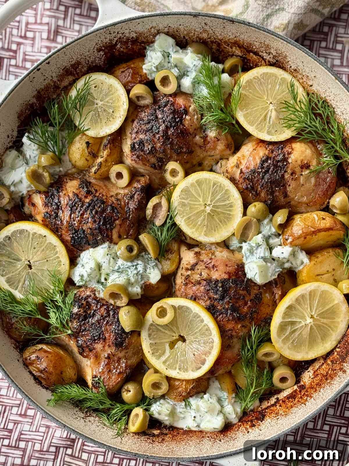 A vibrant close-up of the Greek chicken and lemon potatoes, showing the golden-brown chicken skin and tender potatoes.