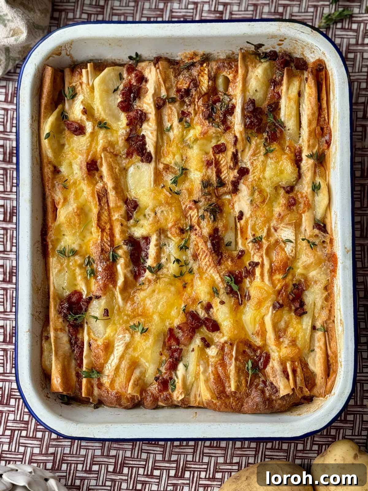 Golden Filo-Wrapped Potato Tart with Melted Brie and Crispy Pancetta 3 Close-up of fresh ingredients for the potato tart: brie cheese, sliced potatoes, pancetta, and fresh thyme sprigs.