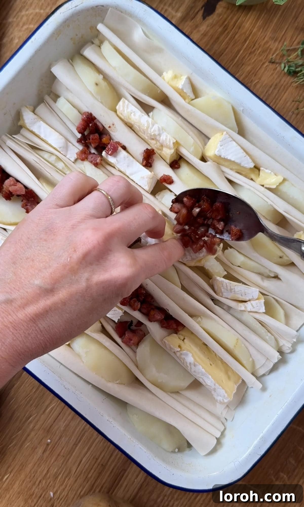 Golden Filo-Wrapped Potato Tart with Melted Brie and Crispy Pancetta 6 Step three: Sprinkling cooked pancetta and chopped red onion over the brie and potato layers, pushing into gaps.