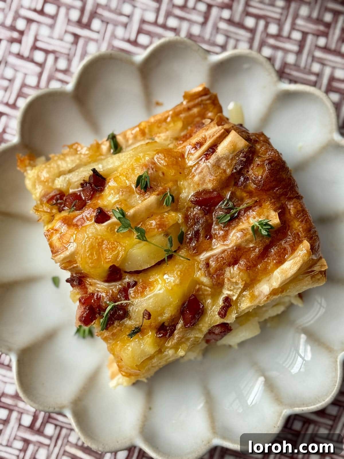 Flaky Filo Potato Tart with Melted Brie and Crispy Pancetta 10 A slice of the crispy potato tart on a plate, showing the layers of filo, potato, brie, and pancetta.