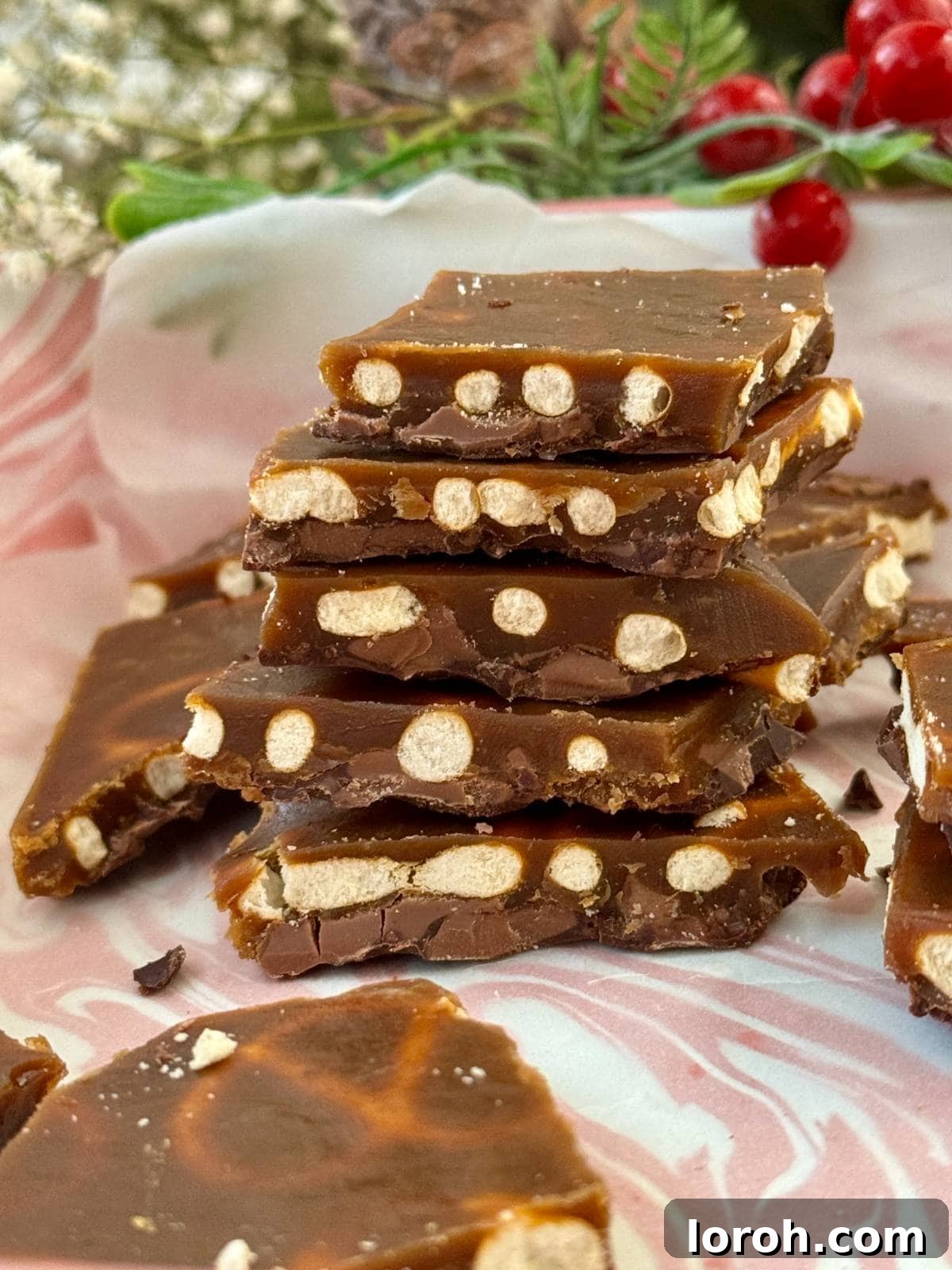 Yuletide Pretzel Crack 2 Stacked Christmas pretzel crack shards on a festive tray, garnished with sprinkles.