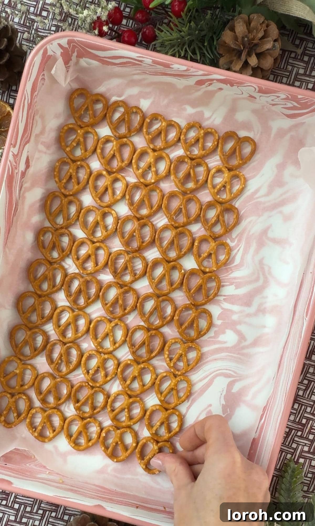 Yuletide Pretzel Crack 4 Arranging pretzels in a single layer on a parchment-lined baking tray.
