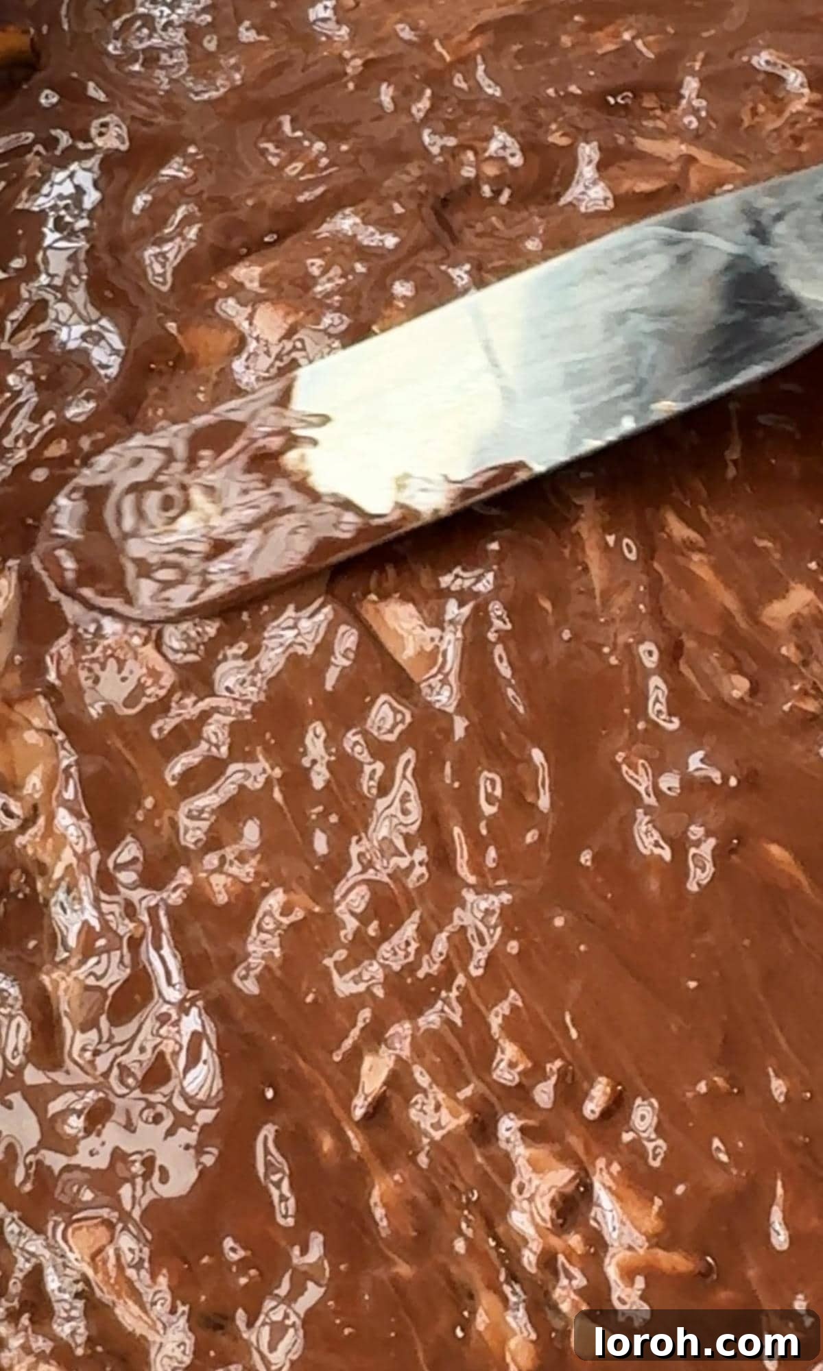 Yuletide Pretzel Crack 8 Spreading melted chocolate smoothly over the set toffee and pretzel base.