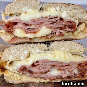 A cross-section of delicious breakfast bagels sandwiches, revealing fluffy eggs, cheese, and mortadella.