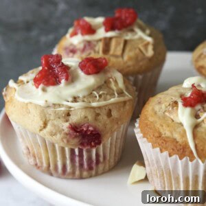 A beautifully baked muffin generously drizzled with decadent white chocolate, ready to be enjoyed.