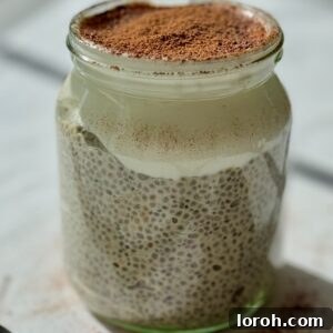 A beautifully layered chia pudding with a creamy yogurt topping, served in a glass jar, perfect for a healthy start.