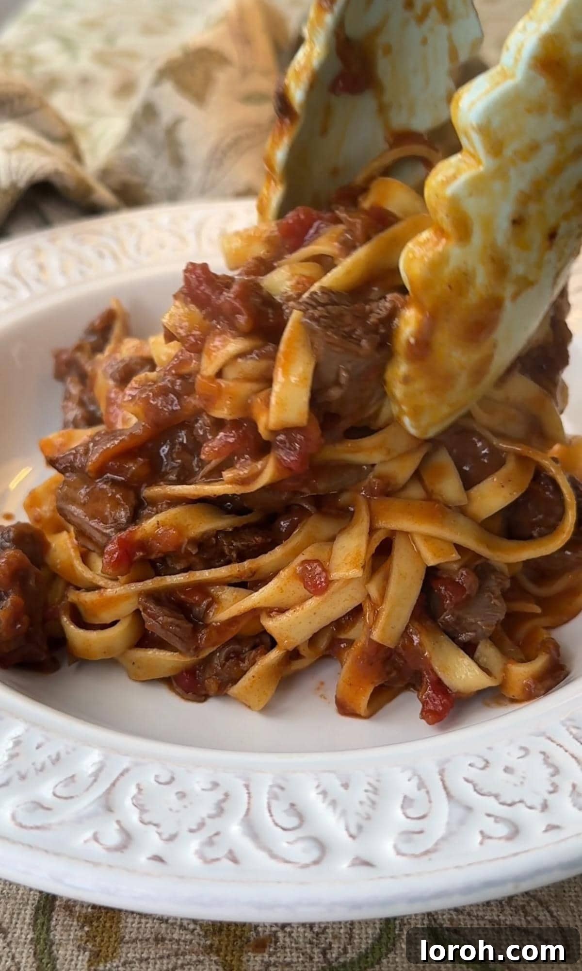 Meltingly Tender Beef Shin Ragu 9 adding beef shin ragu to a bowl.