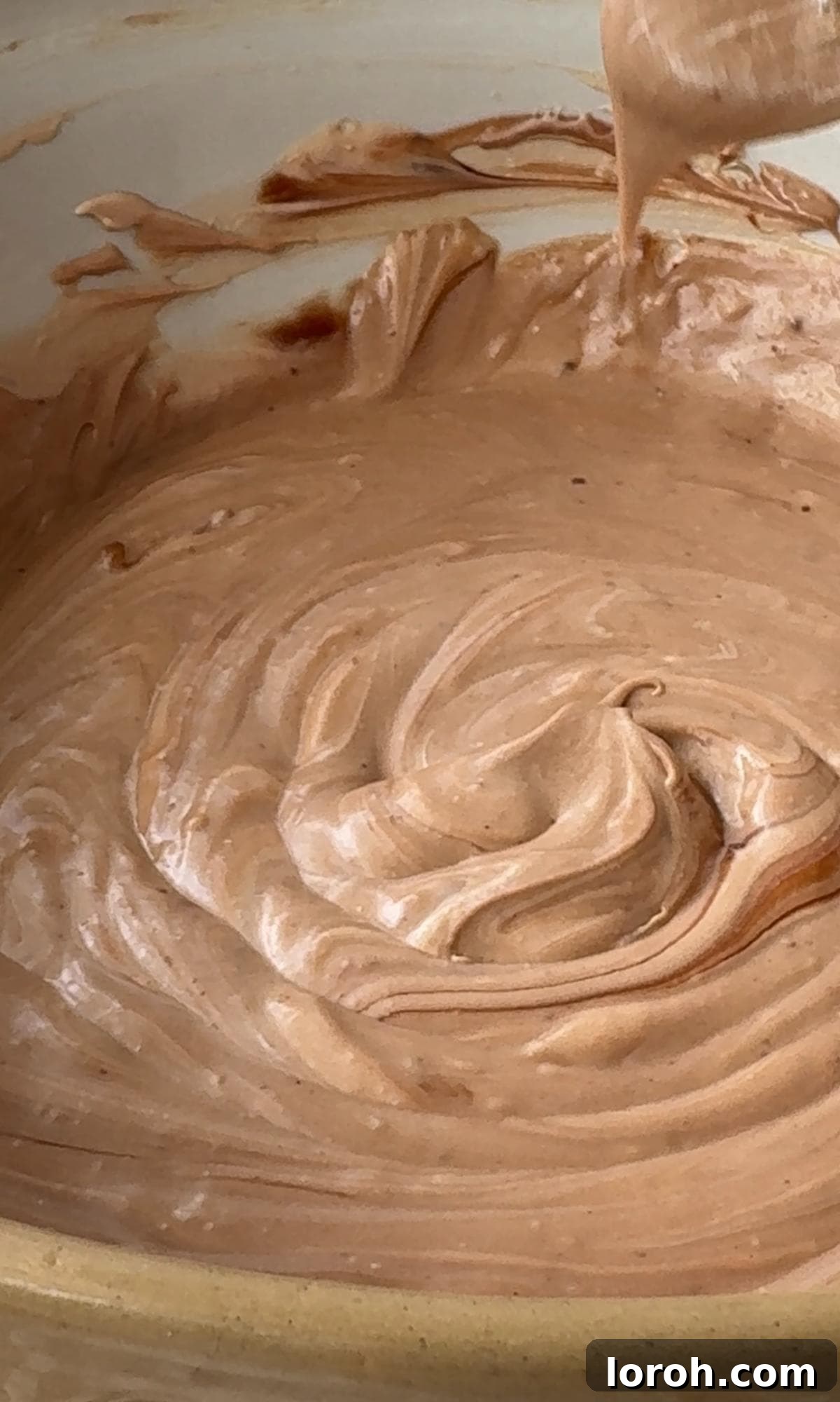 Folding the melted chocolate into the cheesecake mixture.