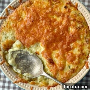 Twice baked mashed potatoes in a dish with cheese on top.