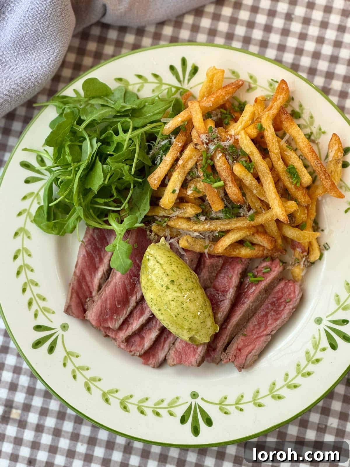 Effortless Homemade Cafe de Paris Butter 3 A generous scoop of Cafe de Paris butter melting over a perfectly cooked steak, served with crispy chips.