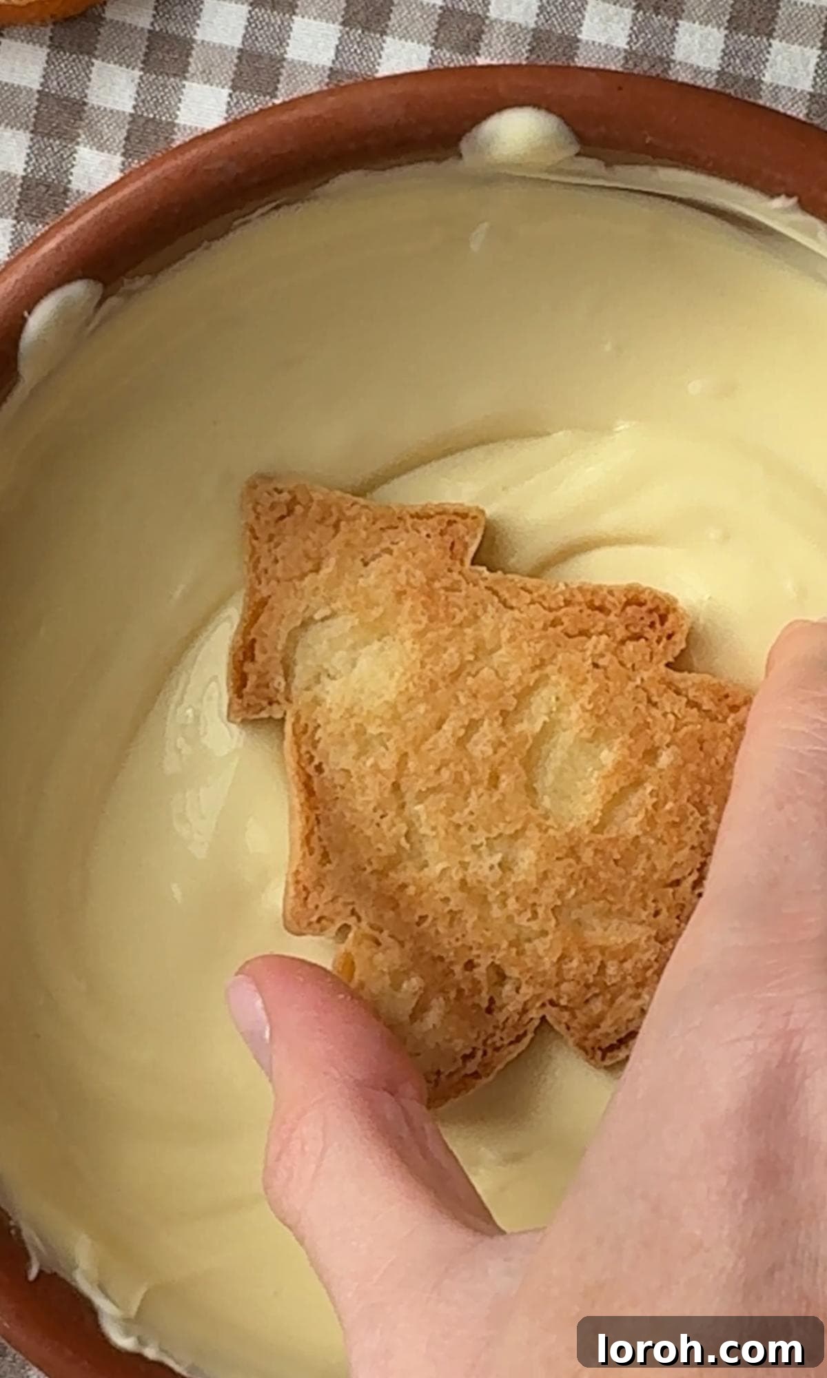 dipping Christmas tree cookies into melted white chocolate.