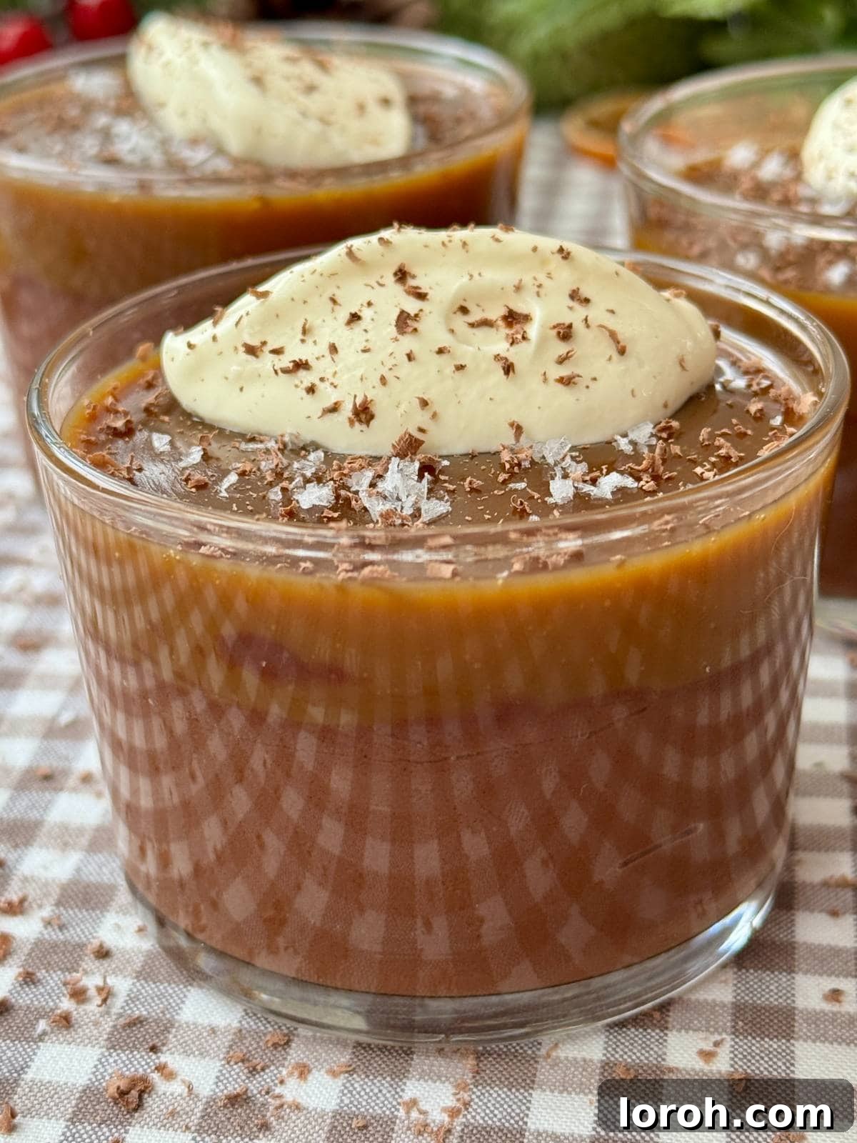 Velvet Chocolate Budino 3 Two glasses of finished chocolate budino, garnished with creme fraiche and flaky sea salt, ready to be served.