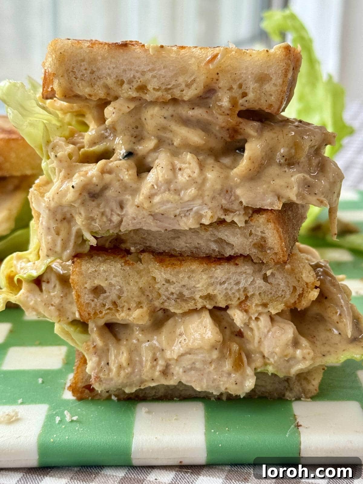 The Ultimate Coronation Chicken Sandwiches 2 A perfectly halved Coronation Chicken sandwich showcasing the creamy curried chicken filling and crisp lettuce.
