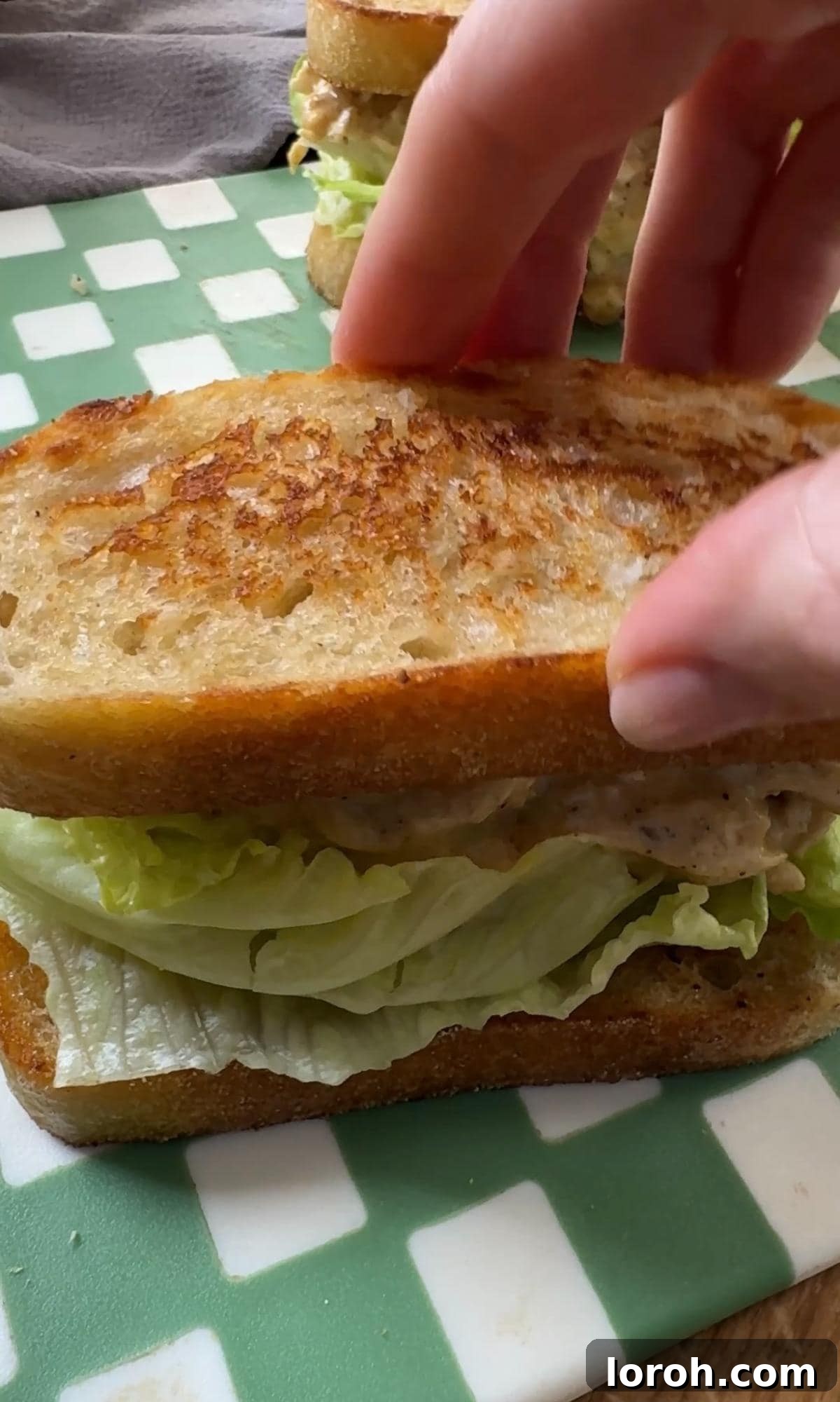 The Ultimate Coronation Chicken Sandwiches 8 Assembling Coronation Chicken sandwiches with a generous scoop of filling and fresh lettuce.