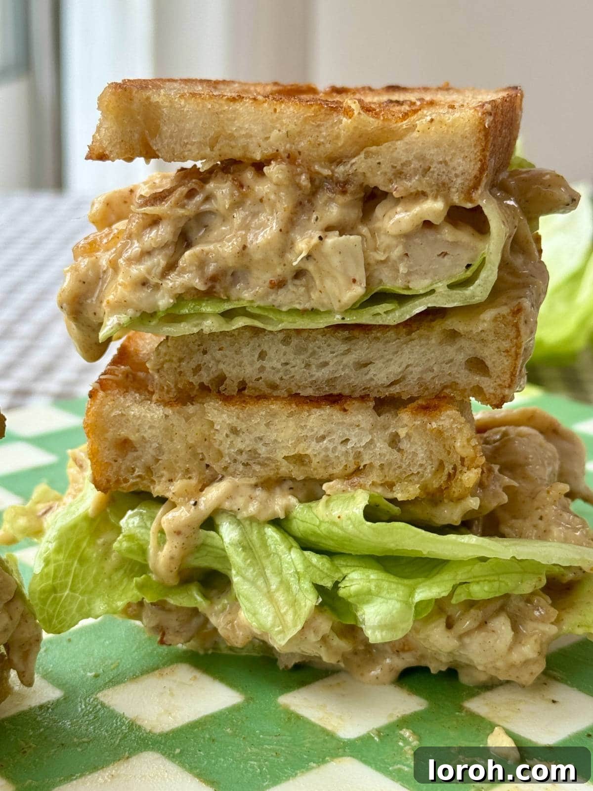 The Ultimate Coronation Chicken Sandwiches 9 A beautifully presented Coronation Chicken sandwich, cut in half, garnished with fresh lettuce.