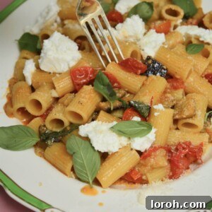 Delicious Aubergine, Tomato & Ricotta Rigatoni pasta dish, inspired by Theo Randall, served in a bowl, garnished with fresh basil.