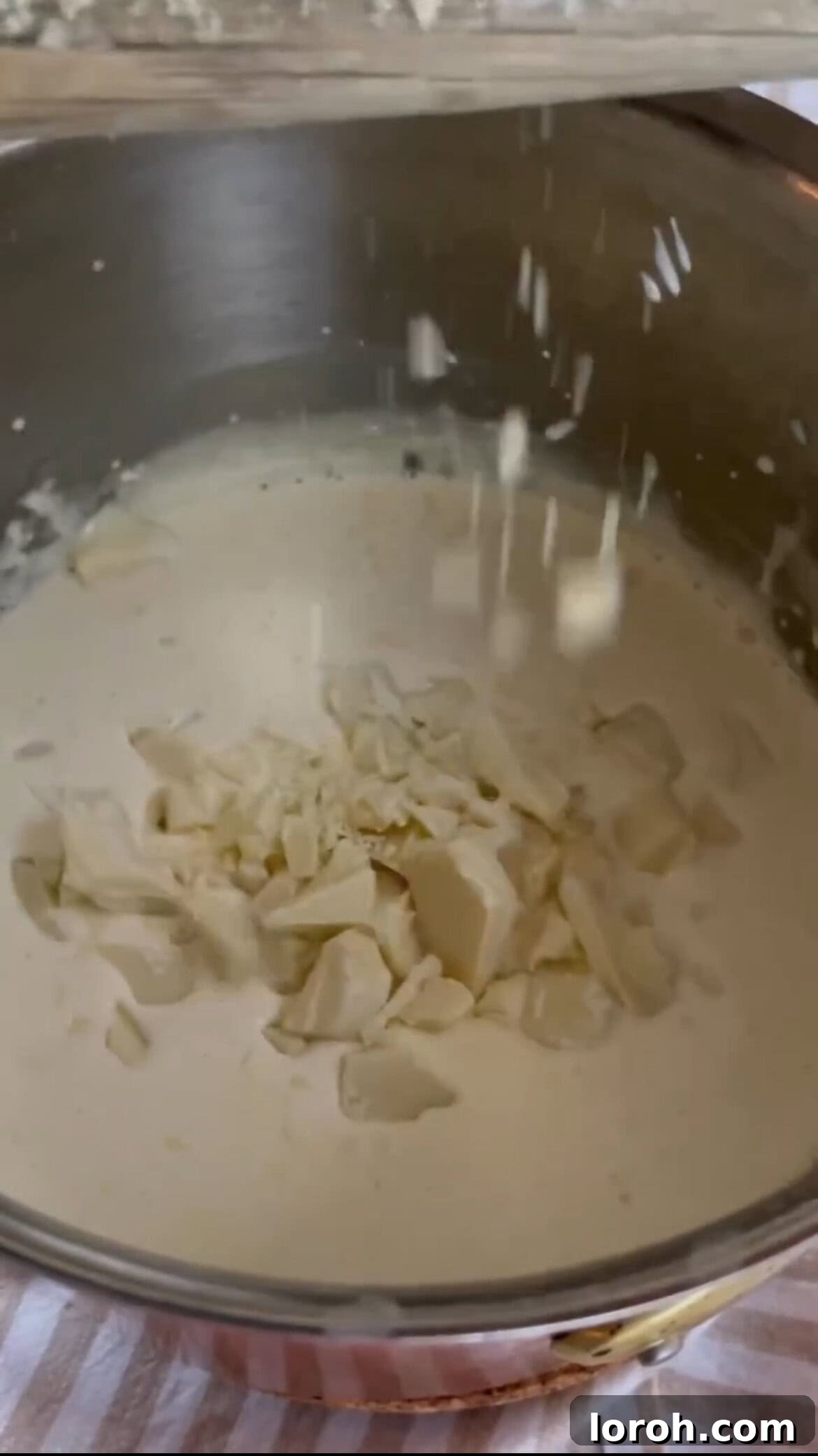 Warm White Chocolate Berry Indulgence 4 Chopped white chocolate melting in gently heated cream in a saucepan.