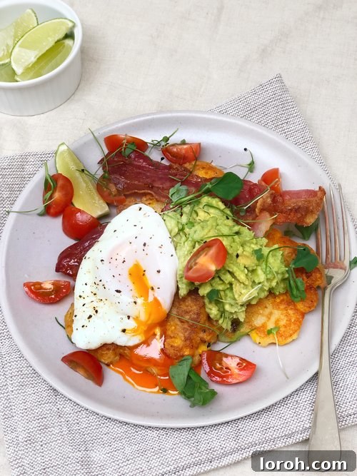 Delicious sweetcorn fritters with avocado, cherry tomatoes and crispy bacon, arranged on a plate for a gourmet meal.
