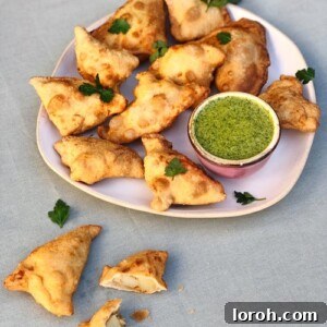 Delicious homemade potato samosas with a vibrant green coriander and mint dipping sauce.