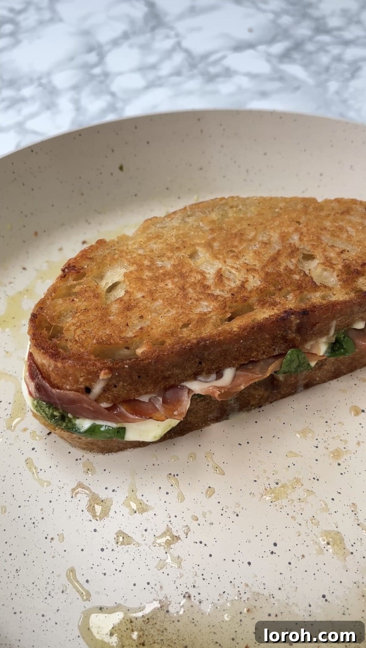 Toasting the prosciutto and mozzarella sandwich in a pan until golden and melted