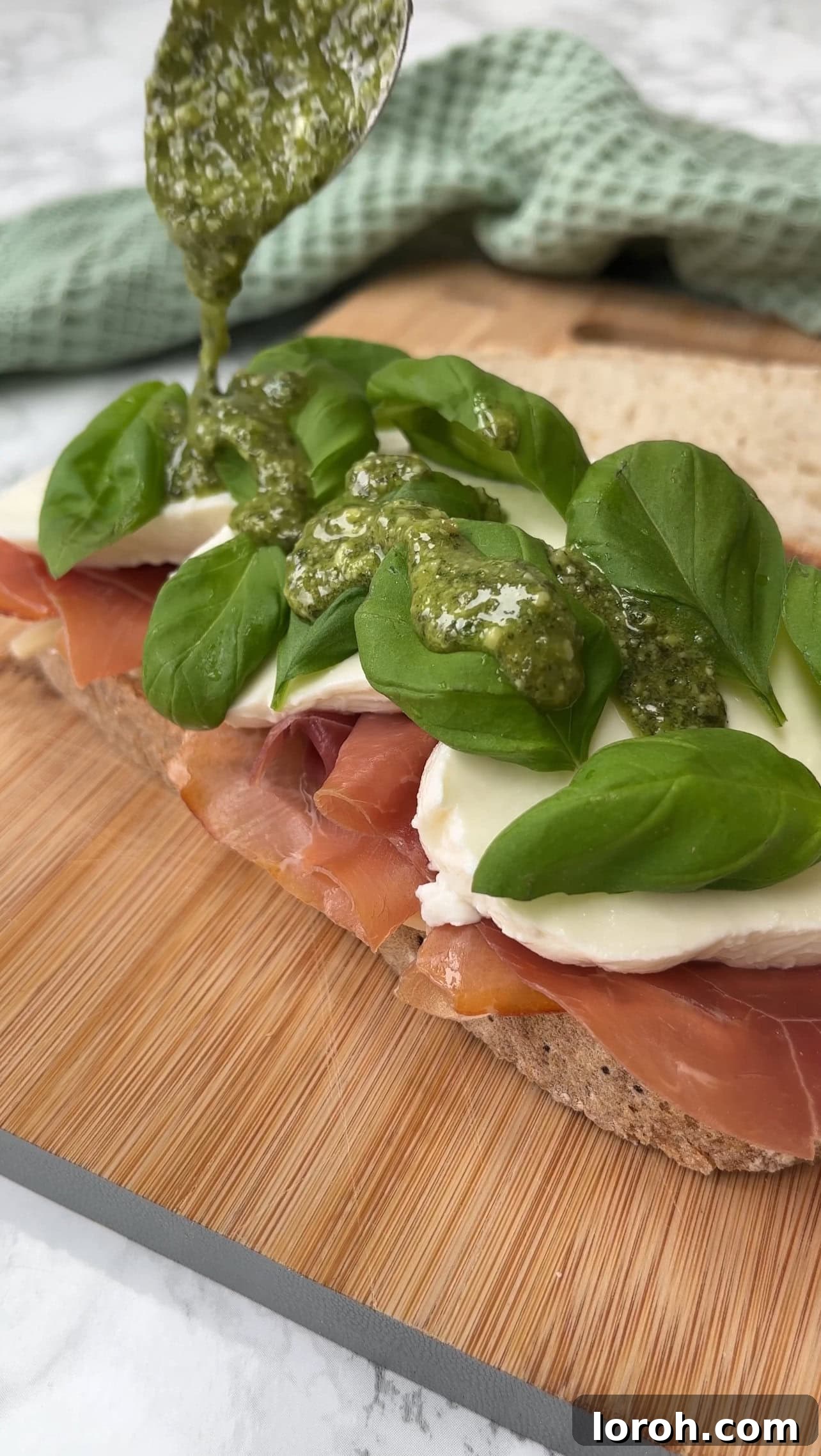 The perfectly toasted Stanley Tucci sandwich, cut in half, revealing the melted cheese and prosciutto
